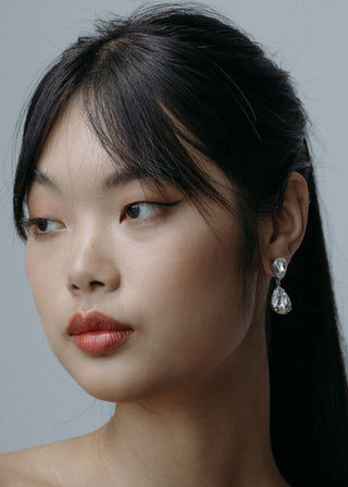 Woman wearing earrings with a neutral background