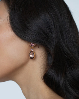 Justine earrings styled with wavy hair, close-up of the emerald-cut crystals in soft tones.