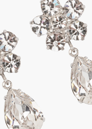 Close-up of a pair of silver earrings with clear gemstones on a white background