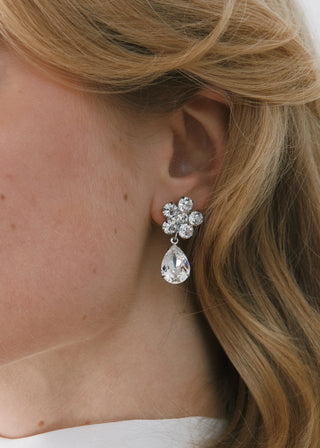 Close-up of a woman wearing a sparkling earring with a white background