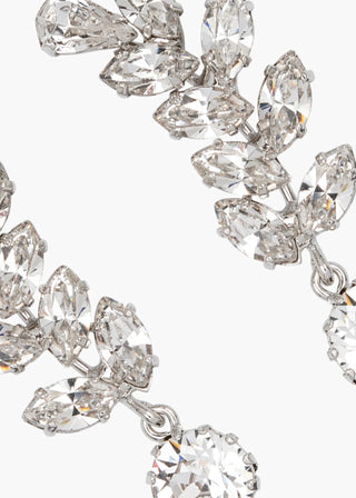 Close-up of a silver earring with clear gemstones on a white background