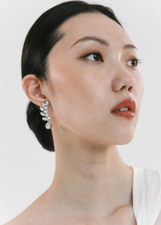 Woman wearing a silver earring against a white background