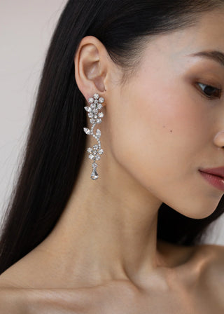 Side profile of a model elegantly wearing Dania Earrings, highlighting the intricate floral design and sparkling crystals.