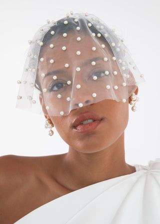 Model wearing the Chiara Veil, demonstrating its ethereal quality with pearls softly framing the face.