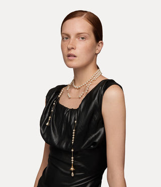 Gold-tone Broken Pearl necklace displayed on a shiny surface, showcasing its unique vintage-inspired design.