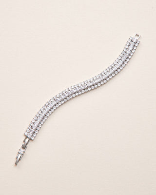 Silver bracelet with clear stones on a beige background