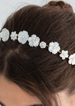 Close-up view of the Jenna Headband, highlighting the delicate floral design and gold-plated finish worn by a model with a chic bun.