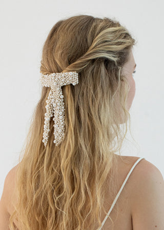 Model styling the Donna Bow Barrette in a half-up hairstyle, showcasing its versatility.