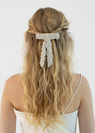 Back view of a model wearing the Donna Bow Barrette, emphasizing its elegant design and French barrette closure.