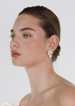 Model wearing the Perlita Earrings, showcasing the earrings' graceful movement and shine against her elegant hairstyle.