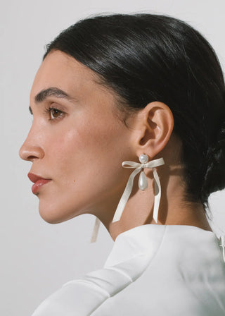 Luxury statement earrings showcasing refined silhouette with fluttering ribbon and sculptural drop accents