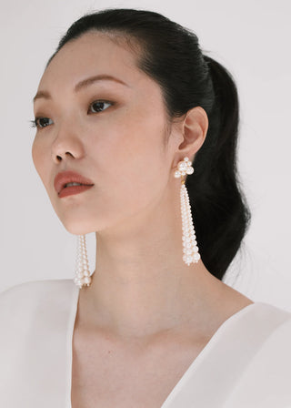 Elegant post-back earrings with crystal pearl clusters and tiered tassels, designed for movement and standout formalwear ensembles.