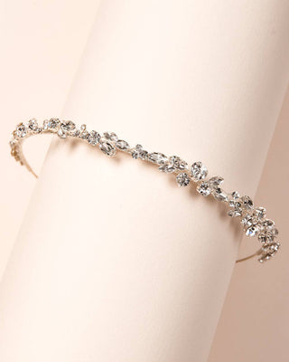 Silver headband with crystals on a beige background