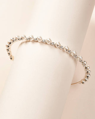 Pearl headband on a mannequin head with a plain background