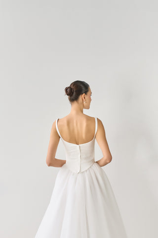 Woman wearing a white wedding dress with a plain background