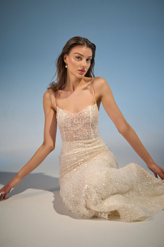 Bridal gown with a flattering mermaid silhouette, scoop neckline, and shimmering beaded details for a luxurious wedding day look.