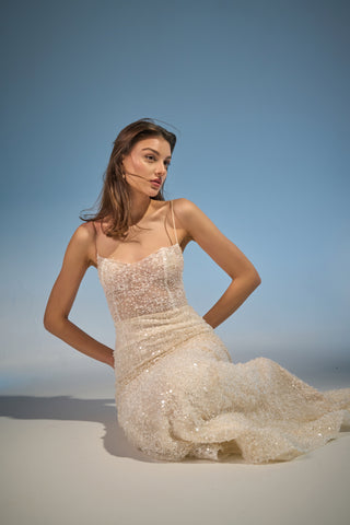 Fitted mermaid bridal gown showcasing a scoop neckline, delicate beaded texture, and spaghetti straps, ideal for formal weddings.