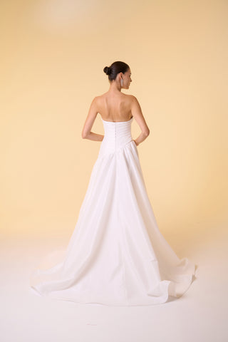 Sophisticated sleeveless bridal gown with a strapless bodice and daring slit, ideal for elegant wedding celebrations.