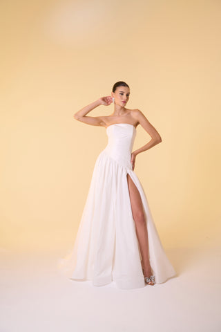 Maxi wedding dress featuring a sculpted dropped waist and voluminous taffeta skirt, designed for modern brides.