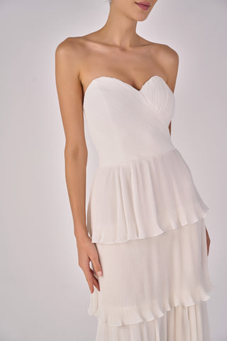 White strapless dress with layered skirt on a plain background