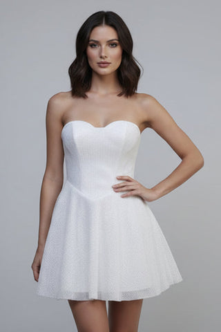 Woman wearing a white strapless dress against a gray background