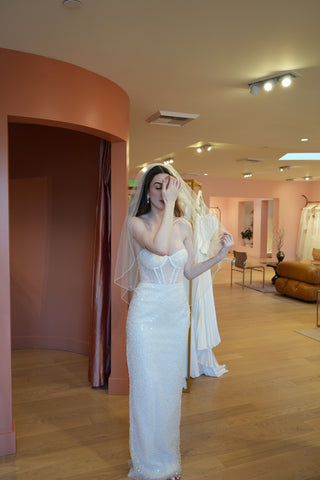 Full-length beaded bridal gown featuring a form-fitting column silhouette, sleeveless design, and captivating shimmering details.