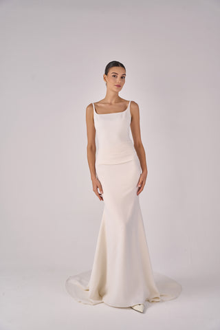 Woman wearing a white wedding dress on a plain background