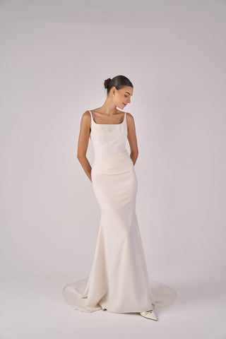 Woman wearing a white wedding dress on a plain background