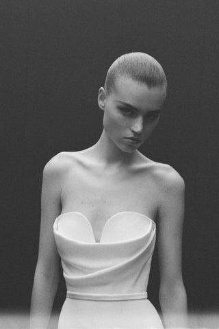 Black-and-white image of a model wearing the Hartley wedding dress by Alex Perry, showing the strapless sweetheart neckline and draped satin crepe from the waist up.