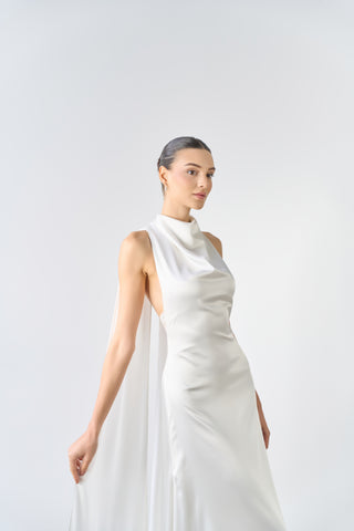 Woman wearing a white sleeveless dress against a plain background