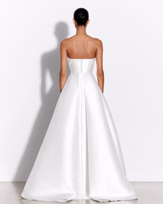 Model wearing the Harper wedding dress by Alex Perry in a back view, highlighting the button detailing and extended train of the strapless gown.