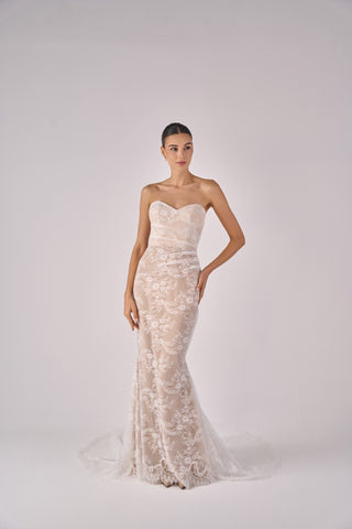 Woman wearing a strapless lace wedding dress on a white background