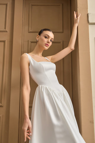 Luxury wedding dress featuring a sleeveless square neckline and delicate draping for a sophisticated, modern bridal look.