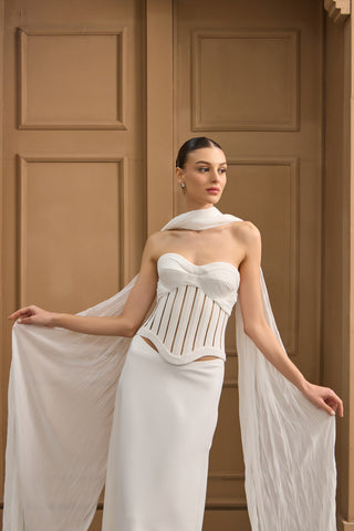 Chic and modern wedding dress with a fitted strapless bodice, boning detail, and a fluid, floor-length column skirt.