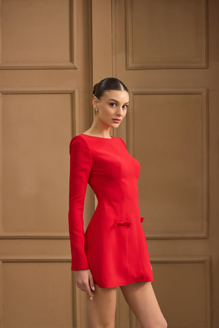 Fashion-forward sheath mini dress with a round neckline, structured long sleeves, and feminine bows for a luxe evening aesthetic.