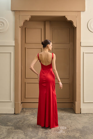 Graceful column gown with a sculpted scoop neckline, sleek satin drape, and an eye-catching thigh slit, designed for luxury events.