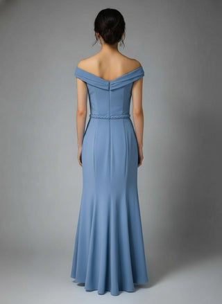 Woman wearing a blue off-shoulder gown against a gray background