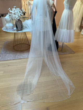 Cathedral-length veil with hand-beaded edge and soft tulle drape for formal bridal ceremonies