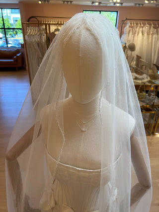Beaded cathedral veil with shimmering trim detail and metal comb attachment for secure, elegant placement