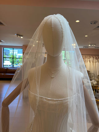 Sheer cathedral veil featuring beaded trim and romantic flowing silhouette, ideal for religious weddings