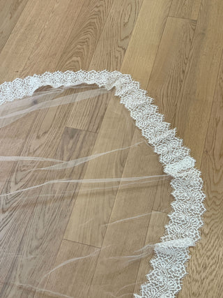Romantic formal veil featuring lightweight tulle, lace edging, and classic drape