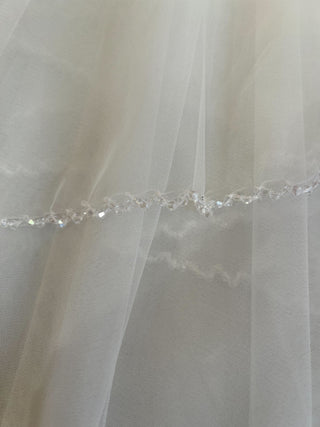 Elegant bridal veil with delicate beadwork along edge and lightweight construction for graceful movement