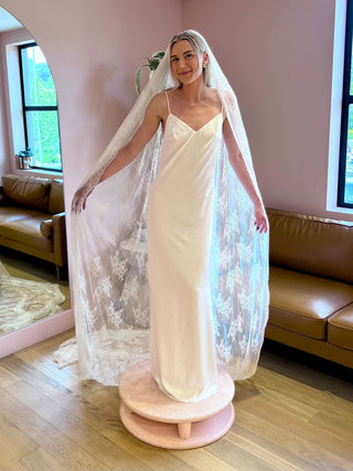 Satin slip wedding dress with column silhouette, delicate spaghetti straps, and refined V-neckline for modern bridal elegance