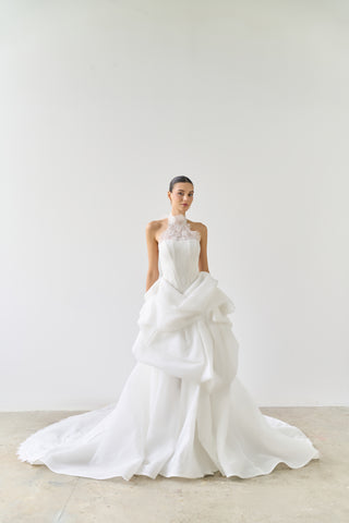 Woman wearing a white wedding dress against a plain background