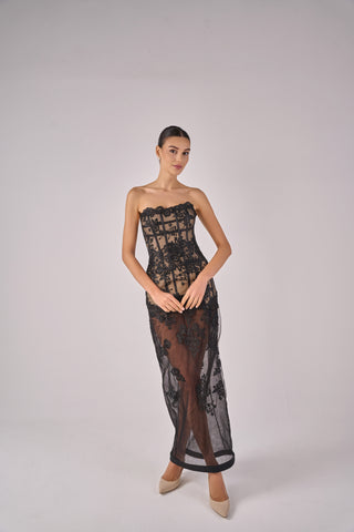Model wearing a black lace strapless gown on a plain background