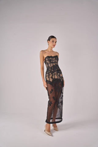 Model wearing a black lace strapless gown on a white background