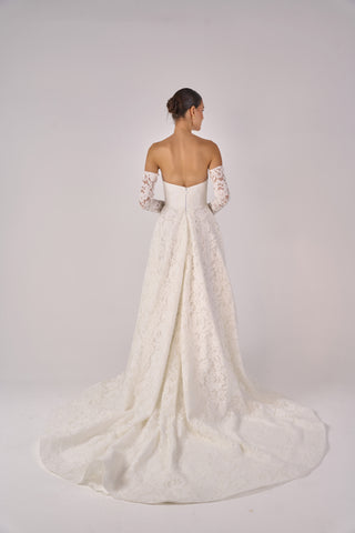 White wedding dress with lace details on a plain background