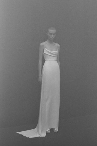 Full-body shot of a model in the Margot wedding dress by Alex Perry, showcasing a draped neckline and floor-length silhouette.