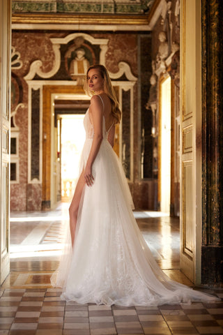 Mia Lavi designer wedding dress featuring delicate ruching, floral lace embellishments, and haute couture detail