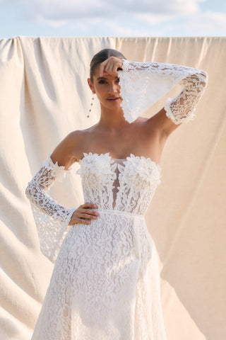 Mia Lavi 2642 couture gown highlighting a romantic off-shoulder neckline, corseted bodice, and wrap slit for modern elegance